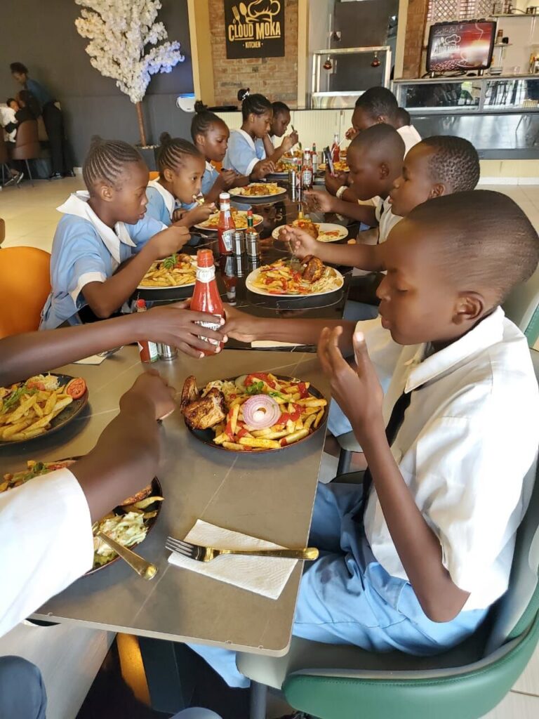 Pupils in school uniform enjoying a meal together at a restaurant