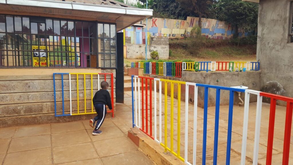 Colourful playground railings in front of a classroom block