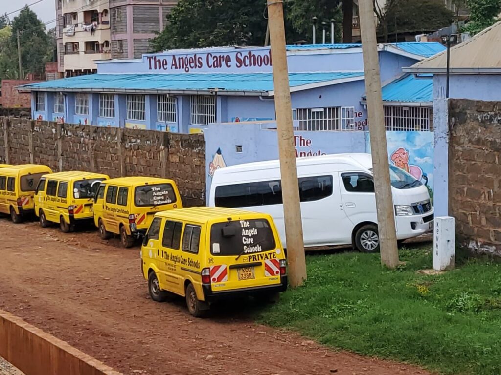 The school’s yellow vans parked along the road beside the school building